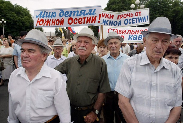 People hold posters reading "Peace for S